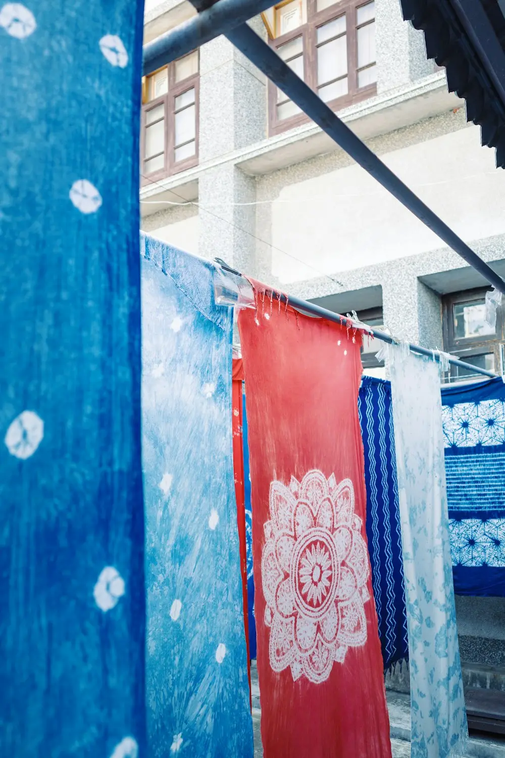 Kain celup biru dan merah digantung di jemuran