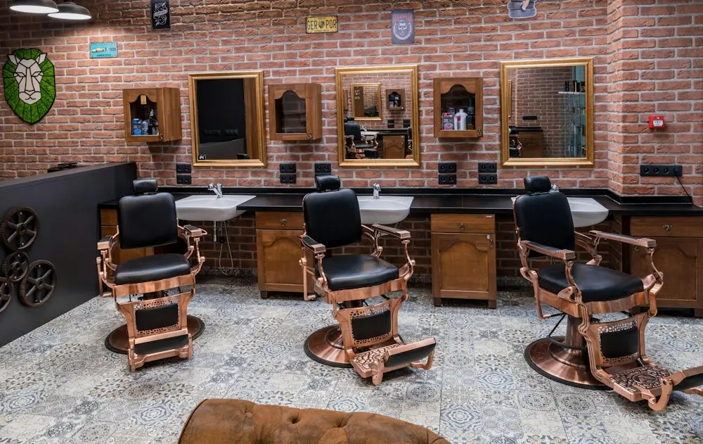 Deretan kursi barber menghadap cermin besar