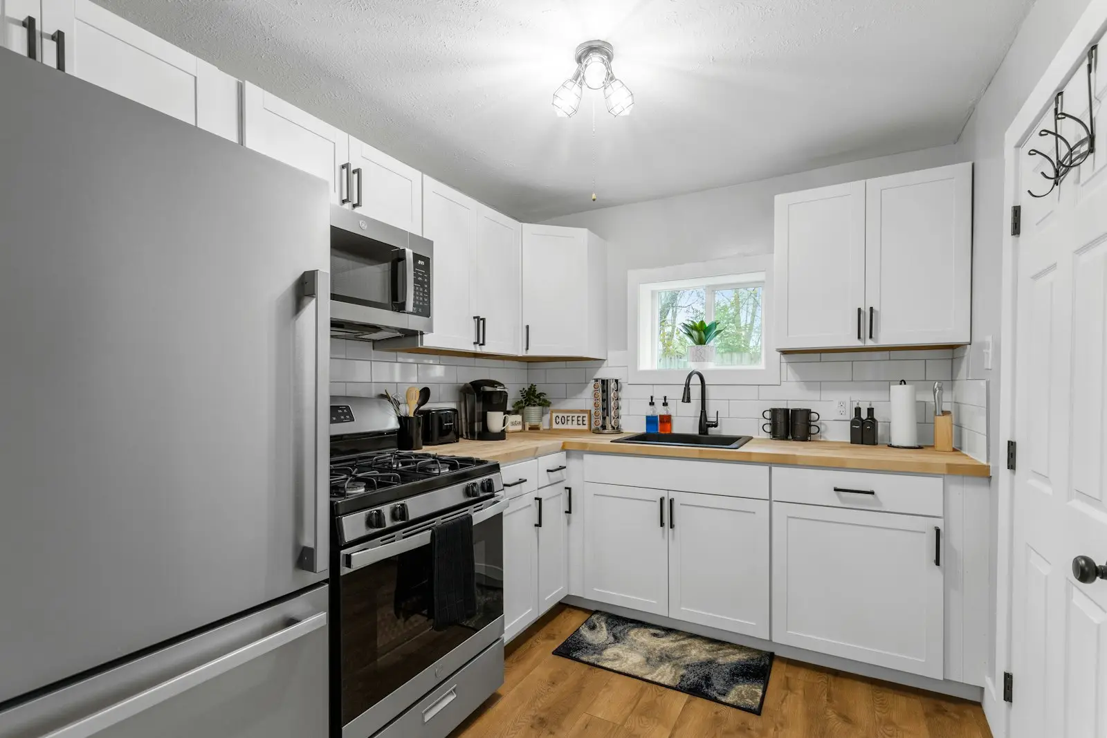 Dapur bersama dengan kulkas dua pintu, kompor, dan lemari putih
