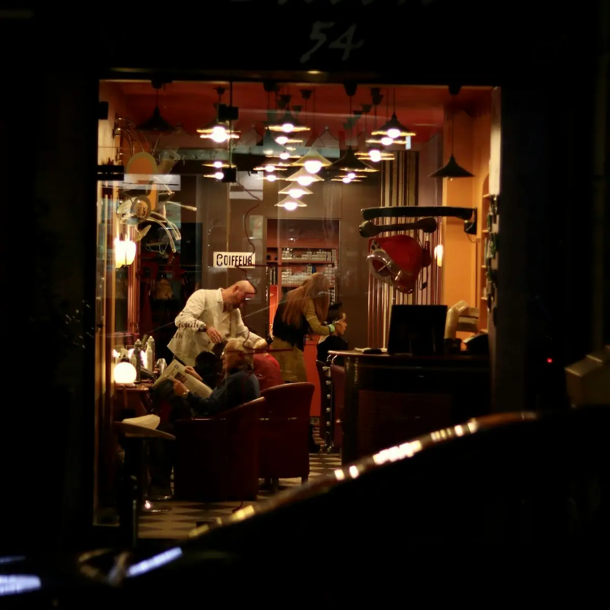 Barbershop yang ramai dilihat dari luar pada malam hari